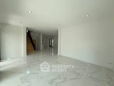 Spacious modern living room with marble flooring and elegant staircase