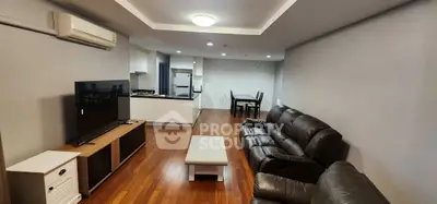 Spacious living room with modern furniture and open kitchen layout, perfect for family gatherings.