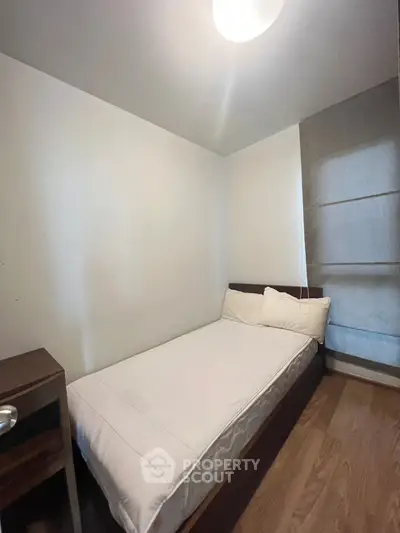 Cozy minimalist bedroom with wooden flooring and natural light