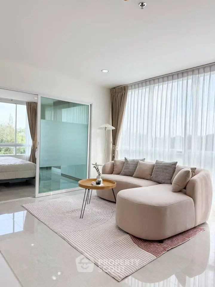 Modern living room with elegant sofa and natural light, featuring a cozy ambiance and stylish decor.