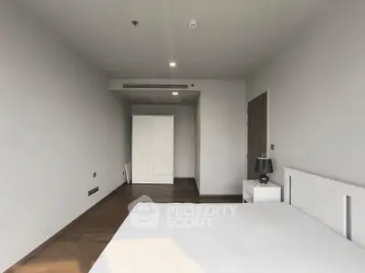 Spacious modern bedroom with minimalist design and ample natural light.