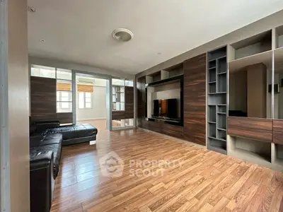 Spacious living room with modern wooden flooring and built-in entertainment unit.