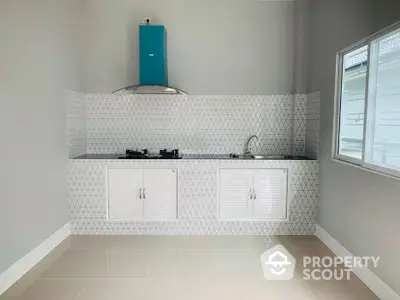 Modern kitchen with gas stove and sleek white cabinets in a bright, airy space.