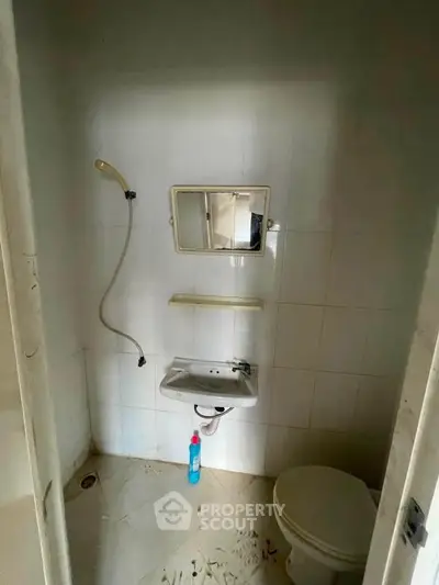 Compact bathroom with shower, sink, and toilet in a minimalist design.