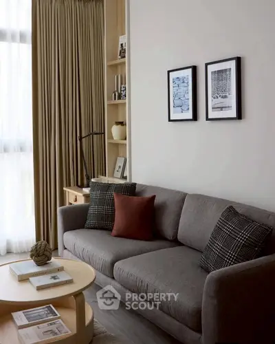 Stylish living room with modern gray sofa, chic decor, and natural light from large window.