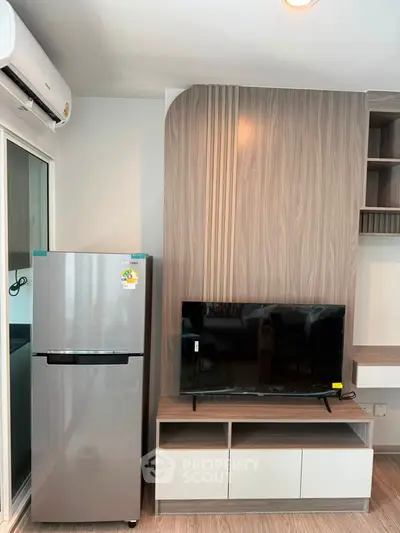 Modern living room with sleek TV unit and stainless steel fridge, perfect for contemporary urban living.