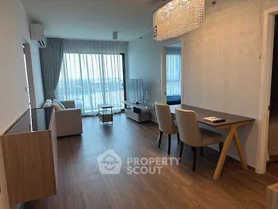 Modern living room with elegant dining area and stunning view, featuring hardwood floors and chic lighting.