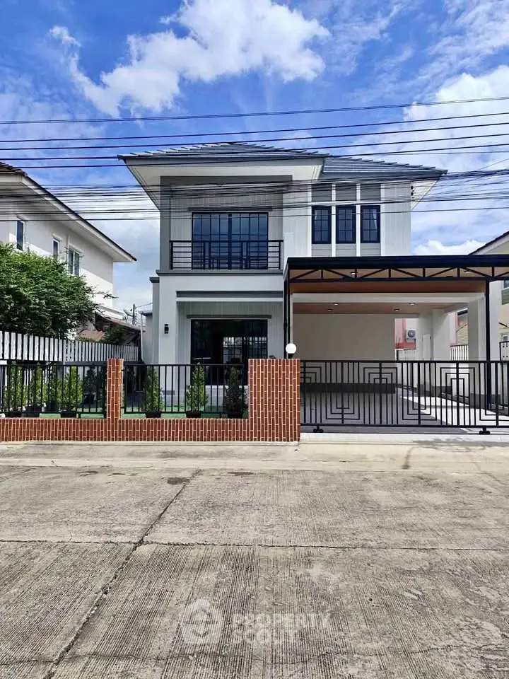 Modern two-story house with sleek design and spacious driveway in a suburban neighborhood.