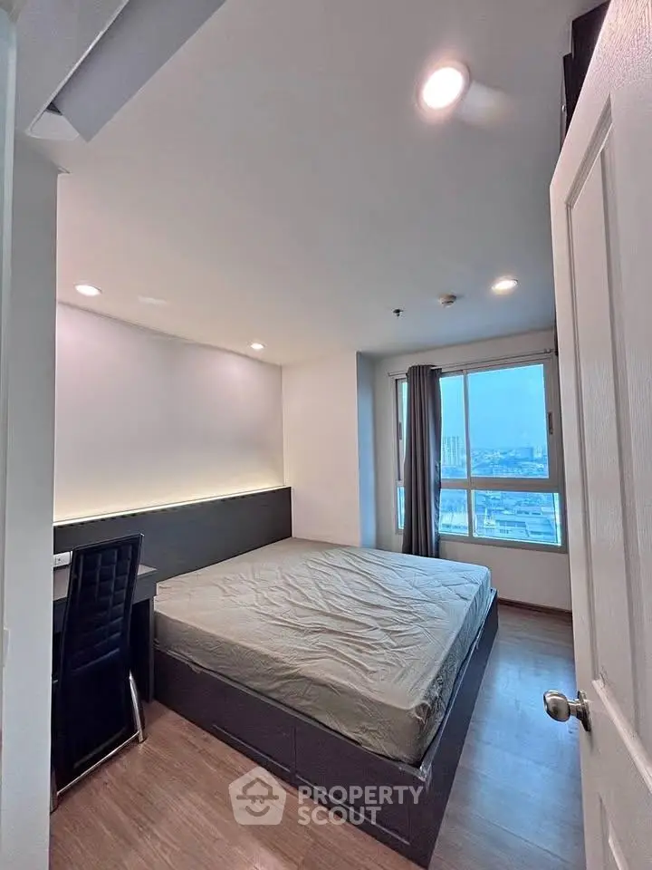 Modern bedroom with city view, featuring a sleek design and ample natural light.