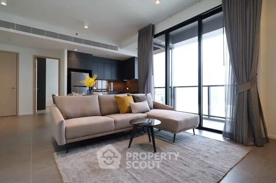 Modern living room with stylish sofa and open kitchen in luxury apartment