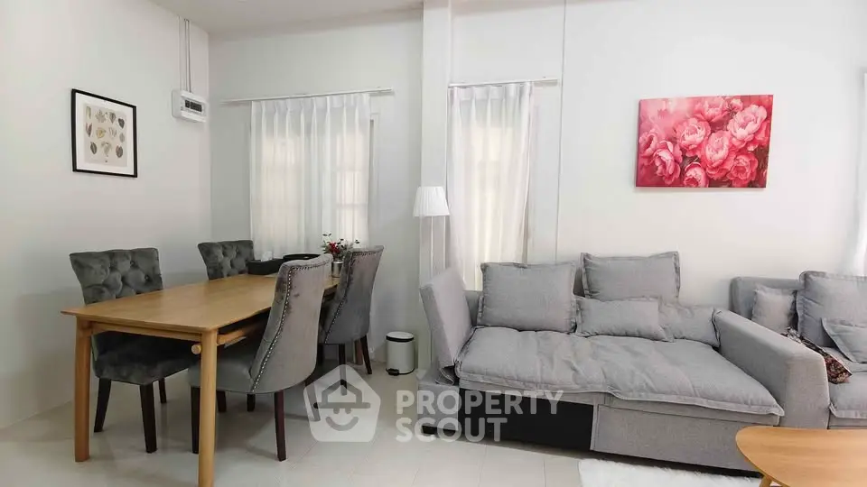Spacious living room with elegant dining area and cozy gray sofas, perfect for modern family living.
