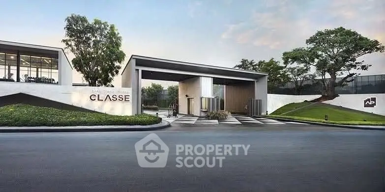 Modern luxury building entrance with sleek design and lush landscaping.