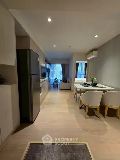 Modern open-plan kitchen and living area with stylish decor and natural light.