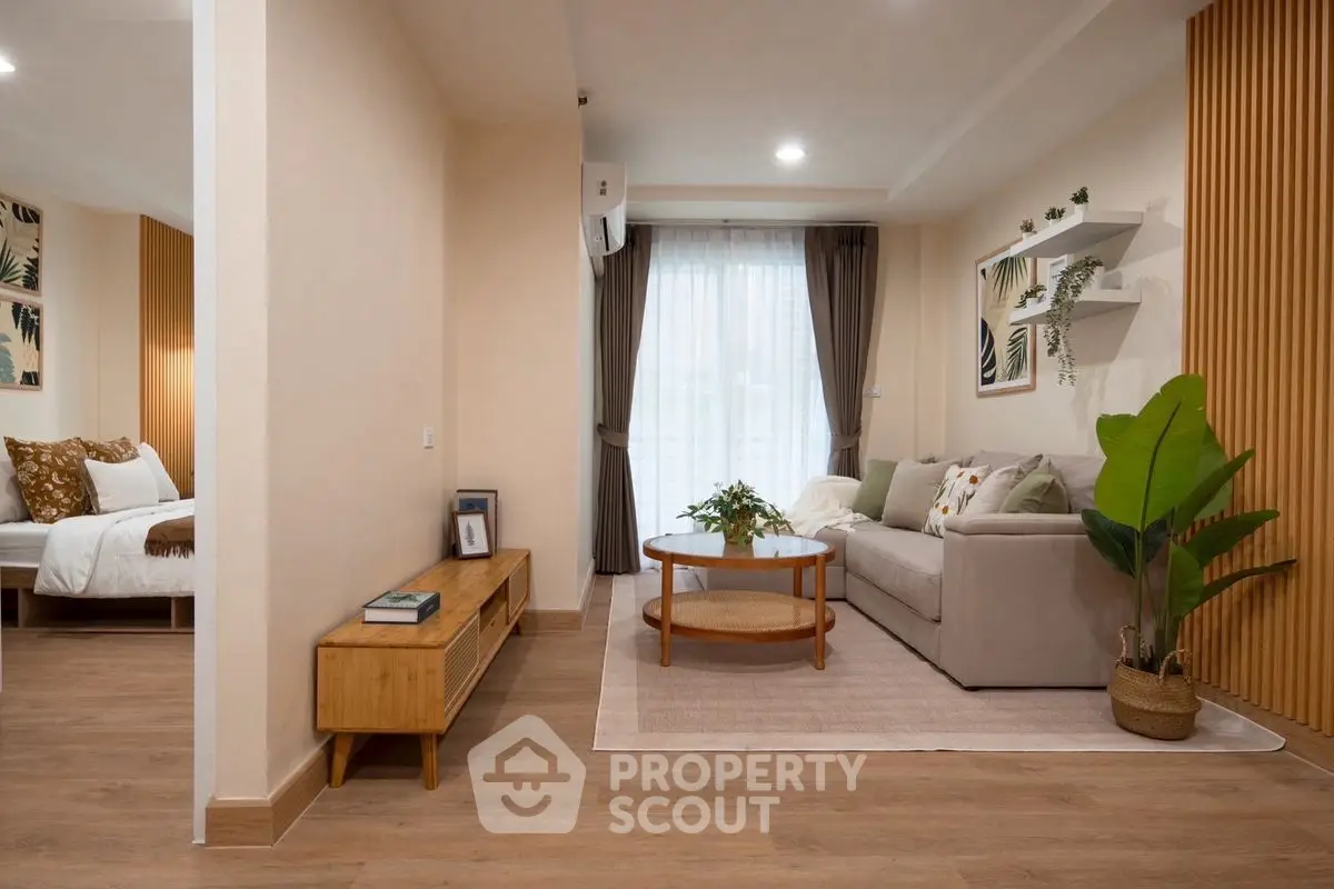Stylish living room with cozy sofa, wooden accents, and natural light in modern apartment.