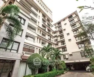 Modern apartment building exterior with lush greenery and spacious balconies.