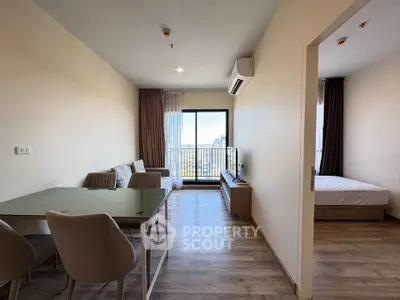 Modern apartment with open living room and bedroom, featuring a balcony with city view.