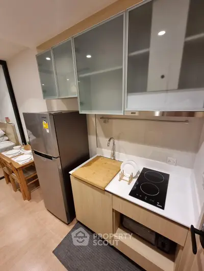 Modern kitchen with sleek cabinetry and built-in appliances in a cozy apartment.