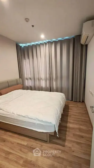 Cozy bedroom with wooden flooring and modern decor in a stylish apartment.