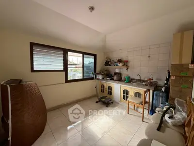 Cozy kitchen with closed layout and ample natural light, featuring tiled backsplash and compact appliances.