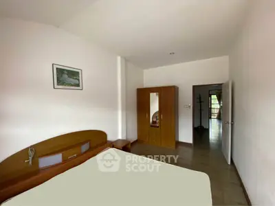 Spacious bedroom with wooden furniture and natural light