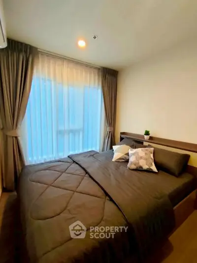 Cozy bedroom with large window and elegant curtains in modern apartment