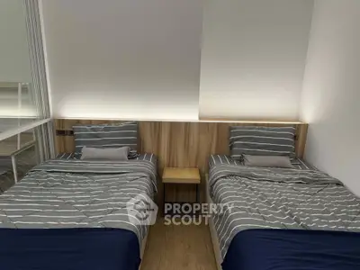 Modern bedroom with twin beds and stylish wooden headboard, perfect for a cozy and minimalist living space.