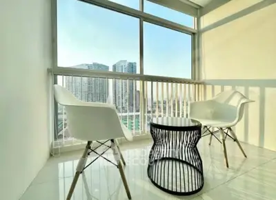 Bright balcony with modern chairs and city view, perfect for relaxation.