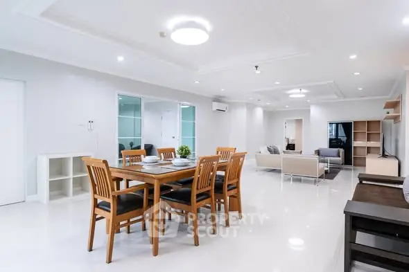 Spacious modern living and dining area with elegant furniture and bright lighting.
