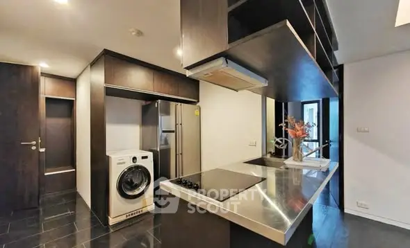 Modern kitchen with sleek appliances and washing machine in stylish apartment