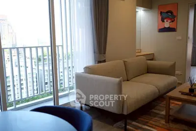Modern living room with stylish sofa and balcony view in high-rise apartment.