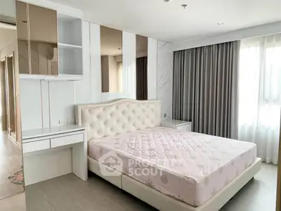 Spacious modern bedroom with elegant decor and ample natural light