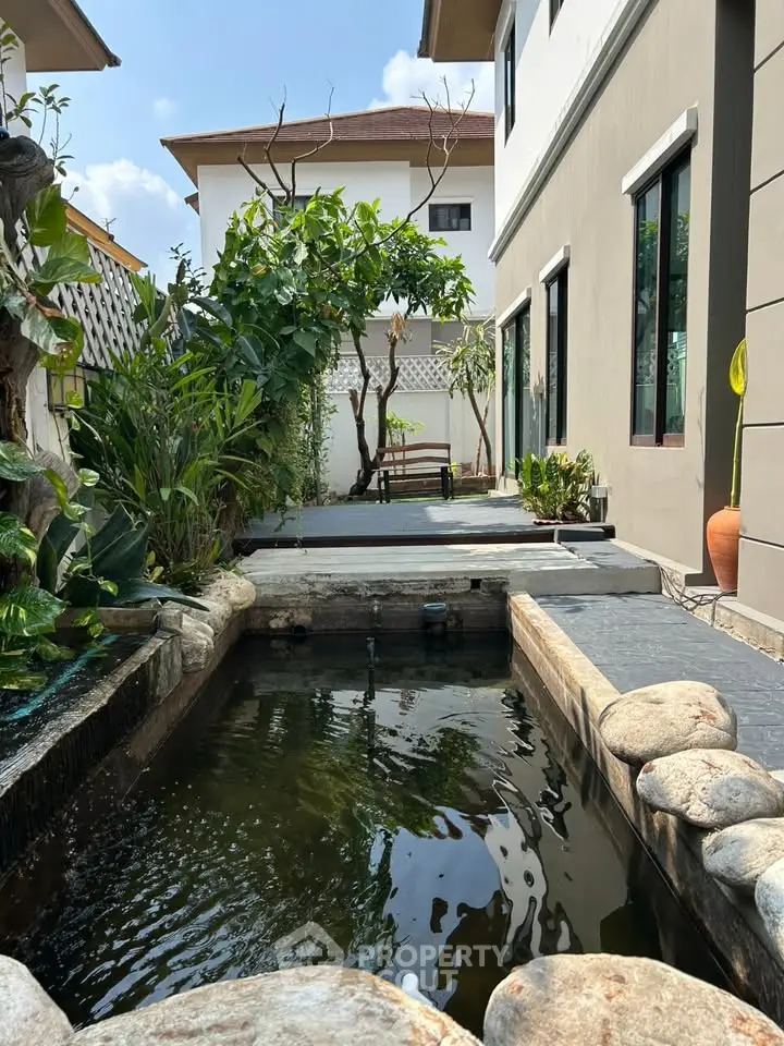 Stunning modern home exterior with serene garden and water feature, perfect for relaxation and outdoor enjoyment.