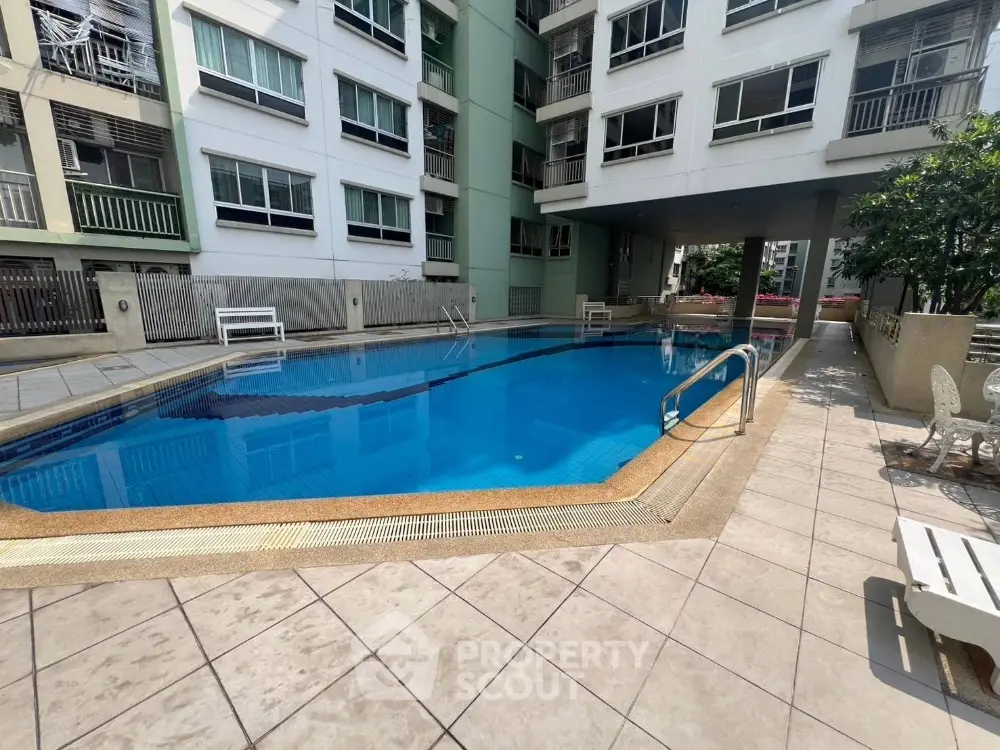 Luxurious condominium with a pristine swimming pool and modern architecture, perfect for urban living.