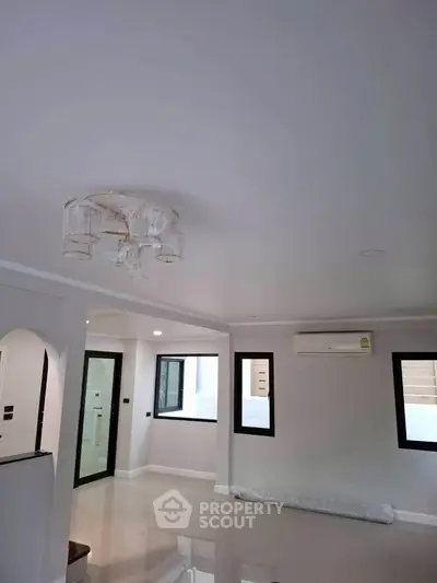 Spacious modern living room with elegant chandelier and air conditioning