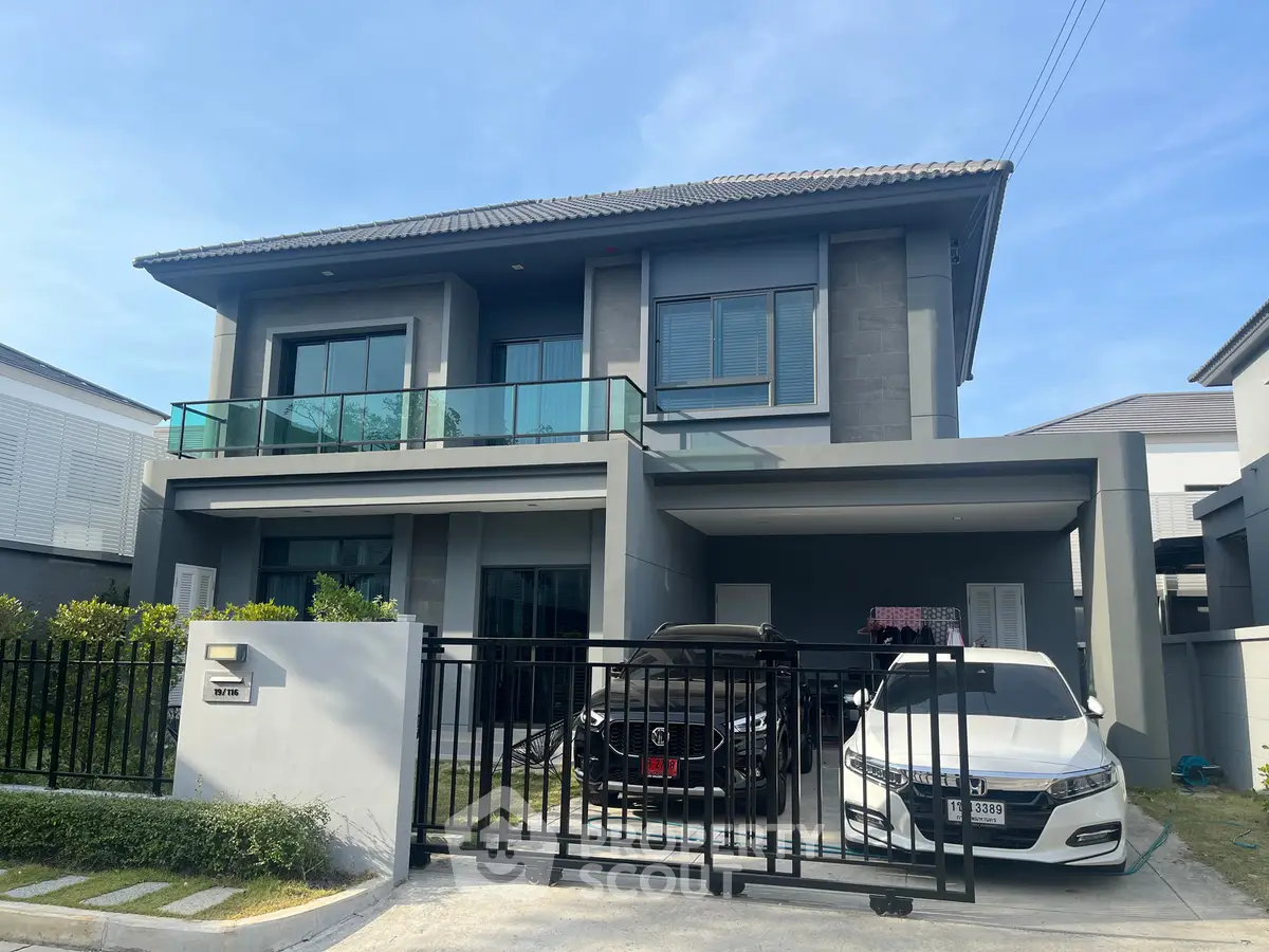 Modern two-story house with sleek design and spacious driveway in a suburban neighborhood.
