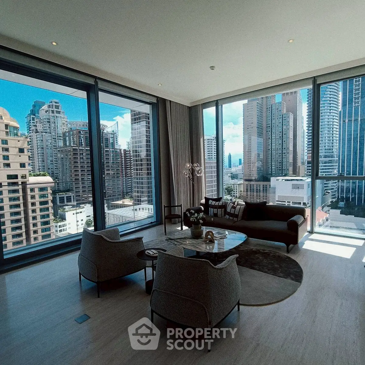 Luxurious living room with panoramic city views and modern furnishings in a high-rise apartment.