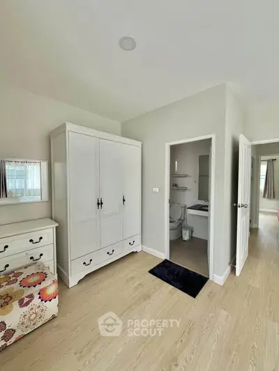 Spacious bedroom with ensuite bathroom and elegant white wardrobe
