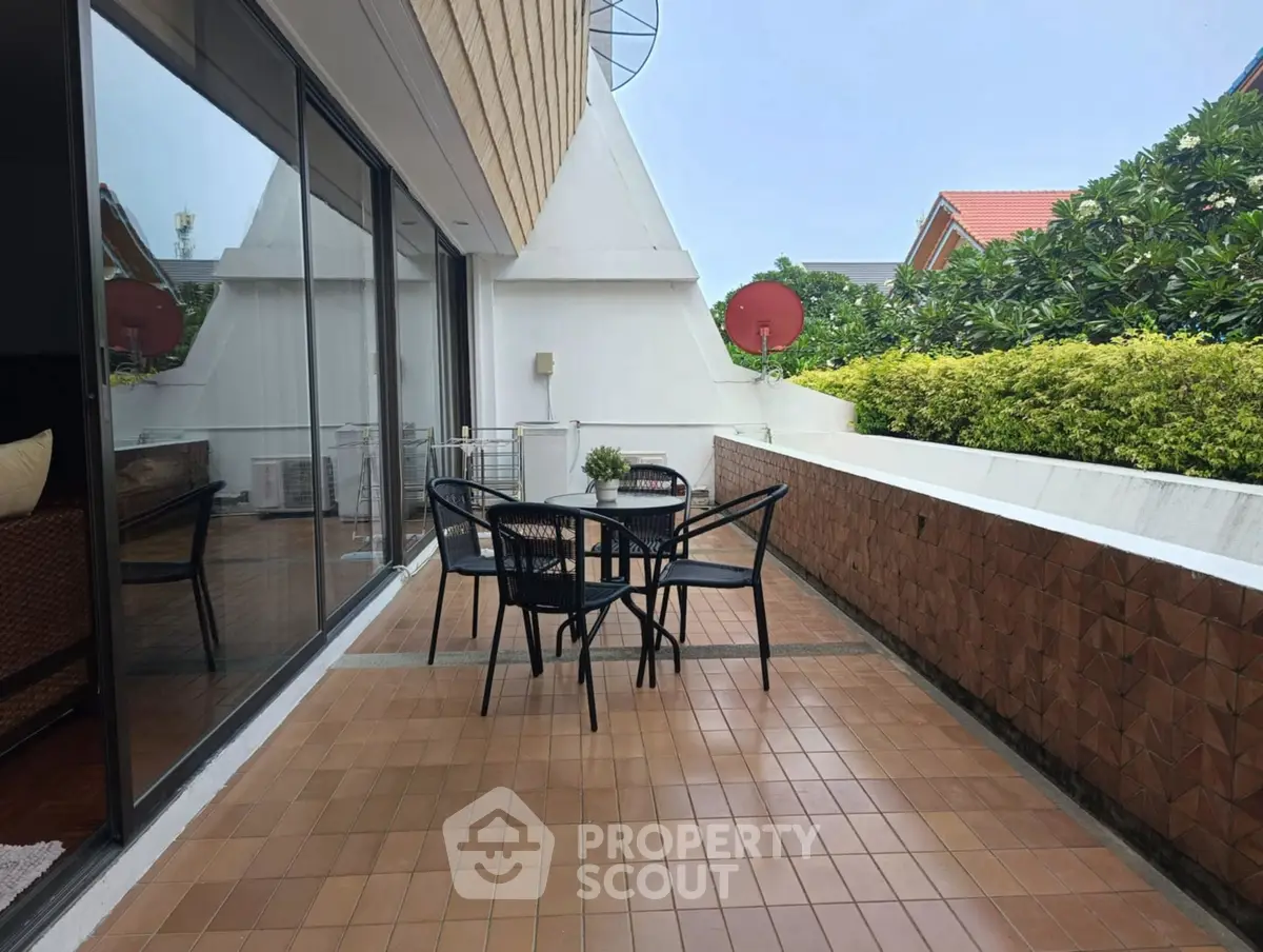 Spacious balcony with outdoor seating and lush greenery view
