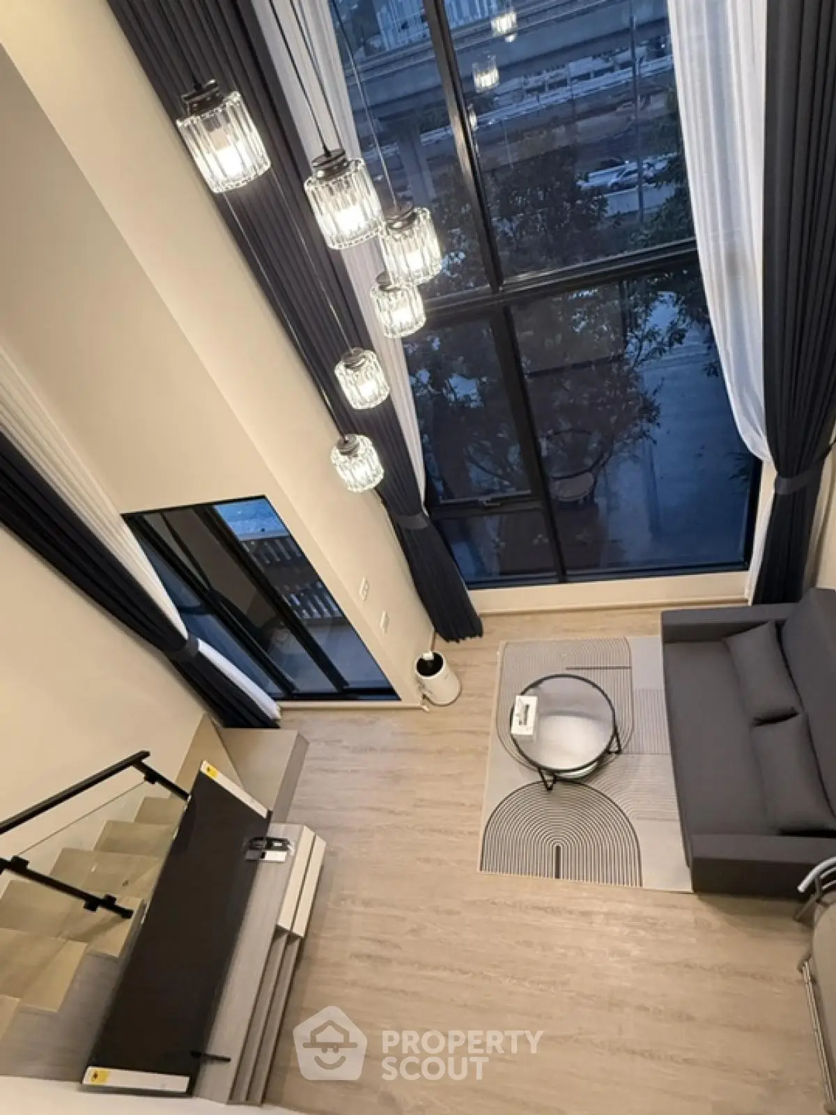 Modern loft apartment with high ceilings and large windows offering a stunning view.