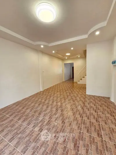 Spacious open-plan living area with modern lighting and tiled flooring, perfect for customization.