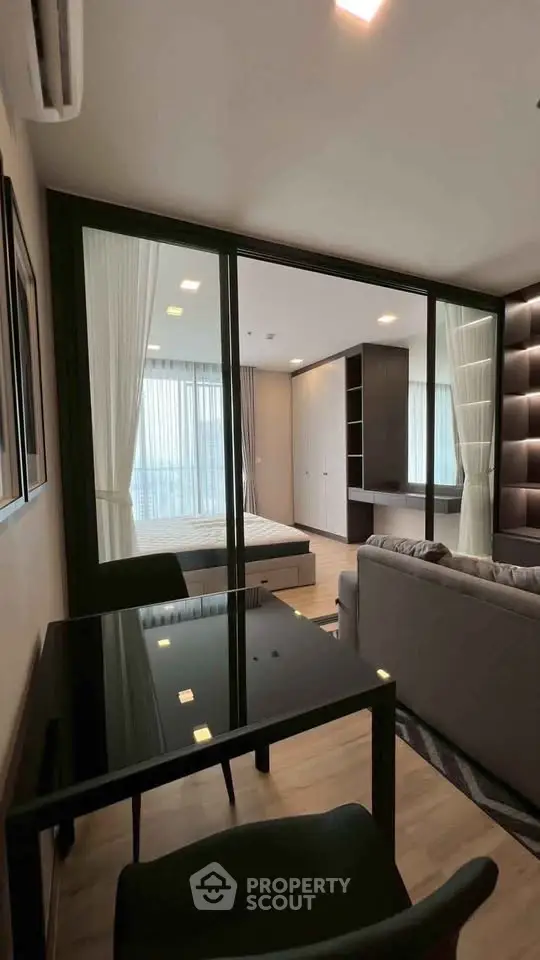 Modern open-plan living room with glass partition and stylish furnishings