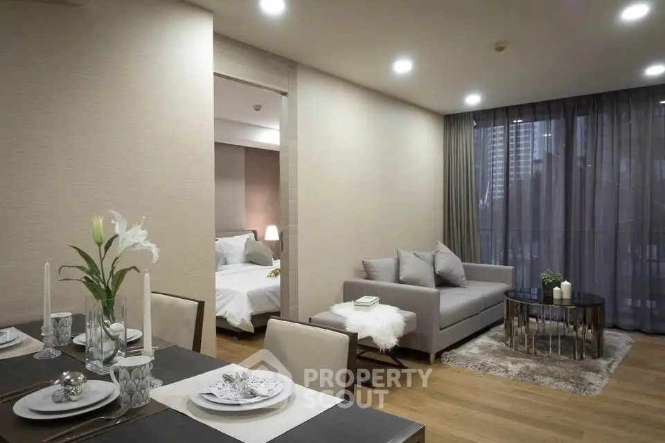 Modern open-plan living room with elegant dining area and cozy bedroom view.