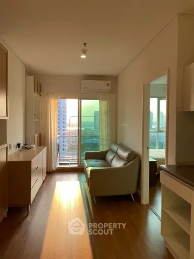 Modern living room with wooden flooring and balcony view in a high-rise apartment