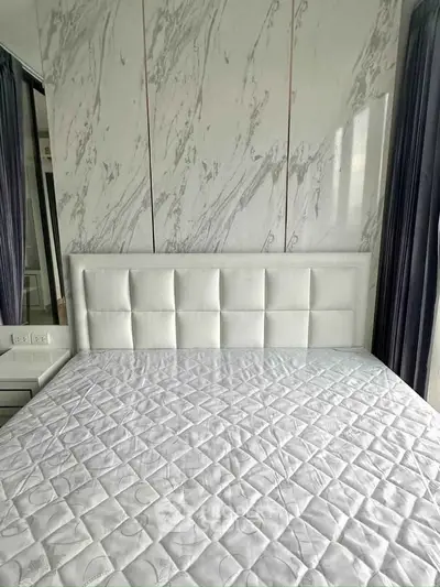 Luxurious bedroom with elegant marble accent wall and plush white headboard