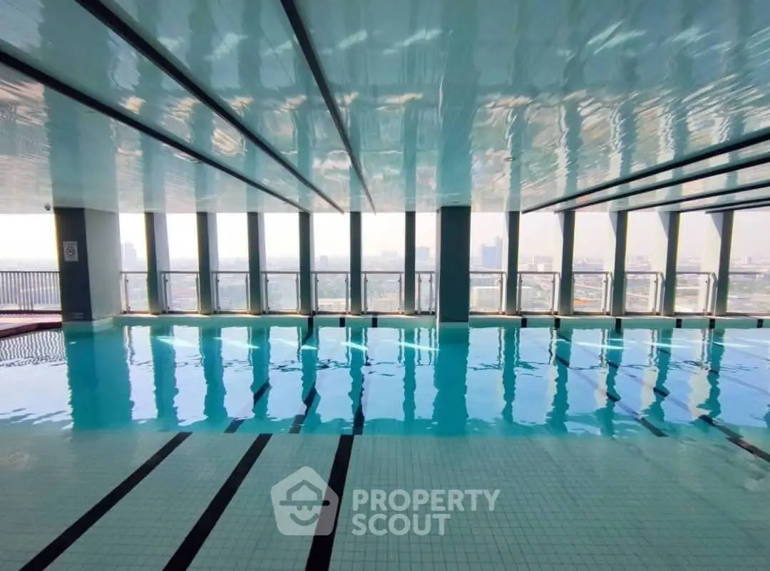 Stunning indoor pool with panoramic city views and sleek modern design.