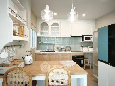 Charming modern kitchen with open layout, featuring sleek appliances and stylish lighting, perfect for culinary enthusiasts.