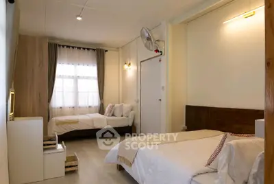 Cozy bedroom with twin beds and warm lighting, perfect for relaxation.