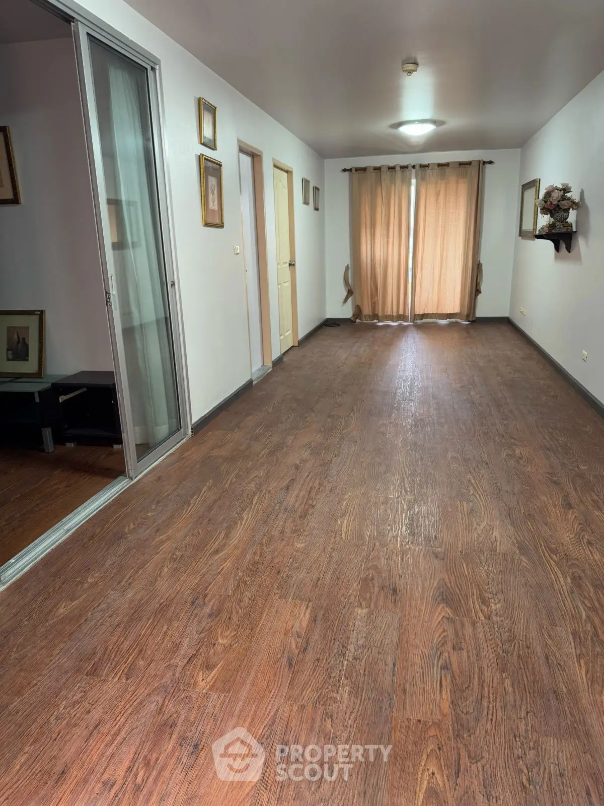 Spacious hallway with wooden flooring and natural light, ideal for modern living.