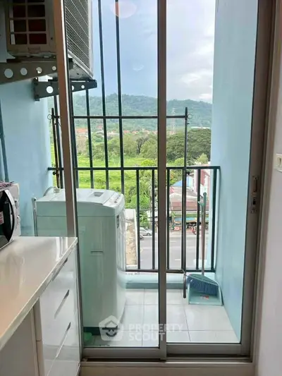 Compact balcony with washing machine and scenic view, perfect for urban living.