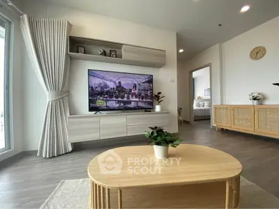 Modern living room with stylish furniture and large TV, showcasing a cozy and inviting atmosphere.